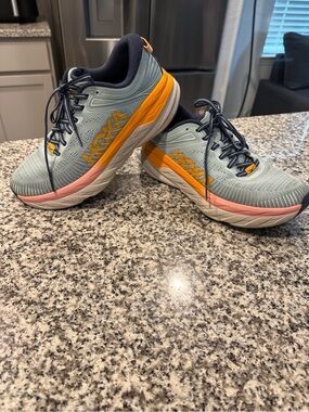 Hoka running shoes in light blue with yellow and pink accents